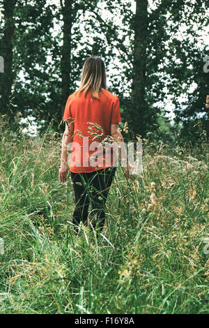 Frau zu Fuß durch ein Feld lange Gras Stockfoto