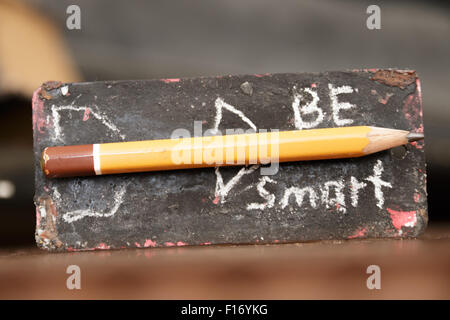Seien Sie clever. Inschrift in Kreide und Bleistift - Rakete. Das Tag mit der Inschrift auf dem Schreibtisch. Stockfoto