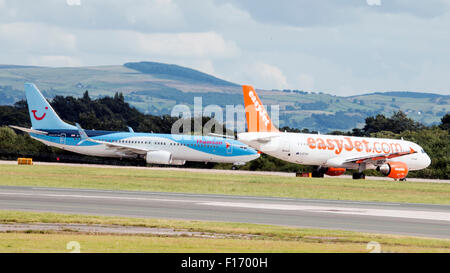 EasyJet, Typ: Airbus A320-214 steht kurz vor dem Start. Thomson Airways, Typ: Boeing 767-304 ist gerade gelandet. Stockfoto