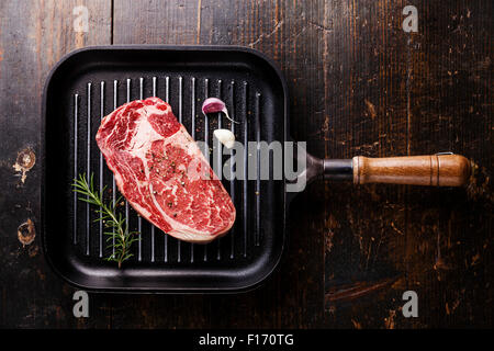 Rohe frische Black Angus Steak Ribeye auf Grillpfanne auf hölzernen Hintergrund Stockfoto