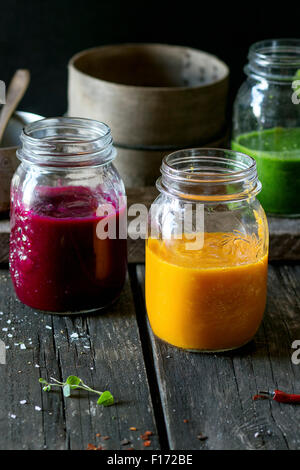 Sortiment an Gemüse Smoothies aus Karotten, rote Beete und Spinat in Glas Gläser. Über alten Holztisch mit Vintage kitchenwar Stockfoto