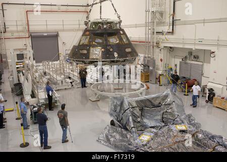 Arbeitnehmer zu senken das Orion-Raumschiff, die auf Exploration Flight Test-1 innerhalb der Launch Abort System Anlage am Kennedy Space Center in Cape Canaveral, Florida 19. August 2015 flog. Orion wird für den Transport zu einer Lockheed Martin-Anlage in Denver, vorbereitet, wo es direkte akustische Feldtests unterzogen werden. Stockfoto