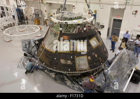 Arbeitnehmer zu senken das Orion-Raumschiff, die auf Exploration Flight Test-1 innerhalb der Launch Abort System Anlage am Kennedy Space Center in Cape Canaveral, Florida 19. August 2015 flog. Orion wird für den Transport zu einer Lockheed Martin-Anlage in Denver, vorbereitet, wo es direkte akustische Feldtests unterzogen werden. Stockfoto