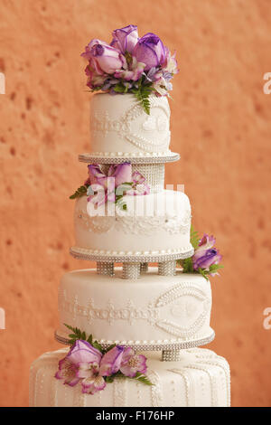 Weiße Hochzeitstorte mit Blumen geschmückt Stockfoto