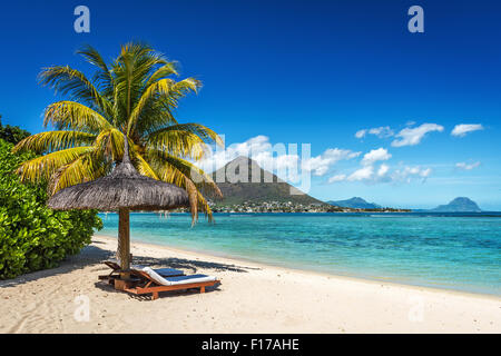 Liegestühle und Sonnenschirm am tropischen Strand Insel Mauritius, Indischer Ozean Stockfoto