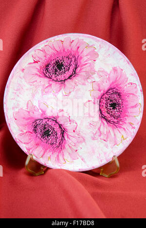 Serviettentechnik dekoriert Blume Modellplatten auf rotem Stoff Hintergrund. Decoupage-tehnique Stockfoto