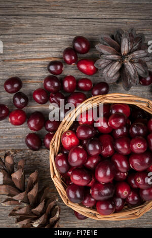 Frische reife Cranberries in Korb auf rustikalen dunklen hölzernen Hintergrund, Draufsicht Stockfoto