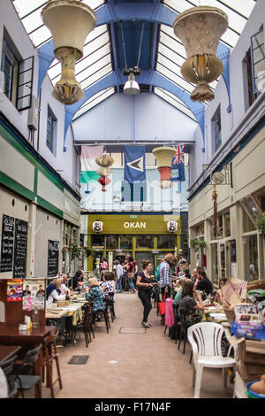 Dorfmarkt Brixton, London, UK. Menschen genießen Essen und trinken in Brixton Village, Brixtons berühmte Markthalle. Stockfoto
