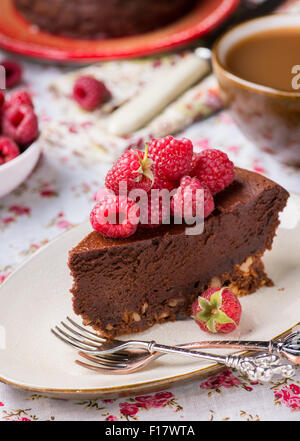 Hausgemachter Schokoladenkuchen mit Himbeeren auf Teller, Tasse Kaffee und Beeren auf Seite, selektiven Fokus Stockfoto