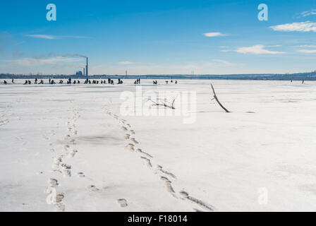 Winterliche Landschaft mit Fischern auf einem zugefrorenen Fluss Dnepr, Ukraine Stockfoto