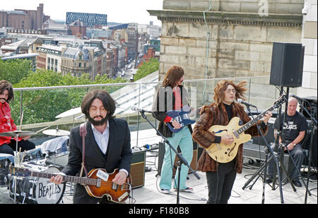 Liverpool, Vereinigtes Königreich. 29. August 2015. Sie Beatles, eine schottische Beatles Tribute Band, neu die Beatles letzten öffentlichen Auftritt auf dem Dach des Apple-Hauptquartier in 1969 durch das Spielen auf Liverpool Central Library am Samstagnachmittag, den 29. August. Es war Teil der internationalen Beatles-Feierlichkeiten. Bildnachweis: Pak Hung Chan/Alamy Live-Nachrichten Stockfoto