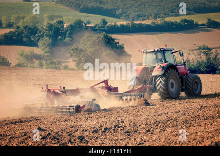 Traktor und Stoppeln Pflug in einem abgeernteten Feld Vintrage gefiltertes Bild Stockfoto