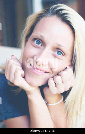 Porträt einer jungen blonden Frau mit großen blauen Augen Stockfoto