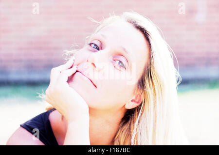 Porträt einer jungen blonden Frau mit großen blauen Augen Stockfoto