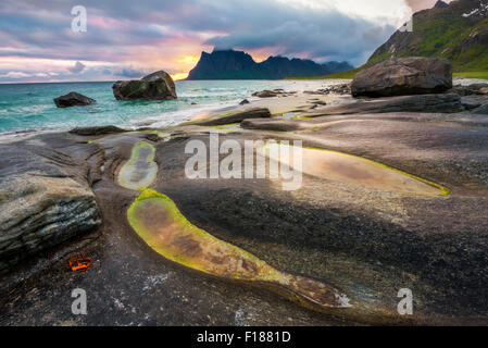 Dramatischen Sonnenuntergang über Uttakleiv Strand auf Lofoten in Norwegen mit einem natürlichen Teich im Vordergrund. HDR verarbeitet. Stockfoto