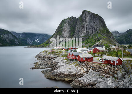 Traditionelle rote Rorbu-Hütten unter Lilandstinden Gipfel in Hamnoy Dorf, Lofoten Inseln, Norwegen. Langzeitbelichtung. Stockfoto