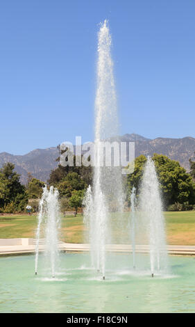 Blaue Spritzen Wasserfontäne mit den Bergen im Hintergrund am Los Angeles Arboretum Garden in Kalifornien, United Stat Stockfoto