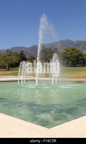 Blaue Spritzen Wasserfontäne mit den Bergen im Hintergrund am Los Angeles Arboretum Garden in Kalifornien, United Stat Stockfoto