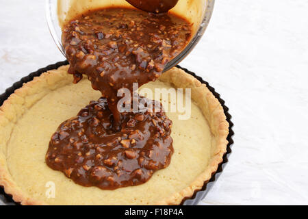 Klebrig, süß Pecan tortencreme in einem Blind gebackenen Mürbeteig Gebäck Fall gießen Stockfoto