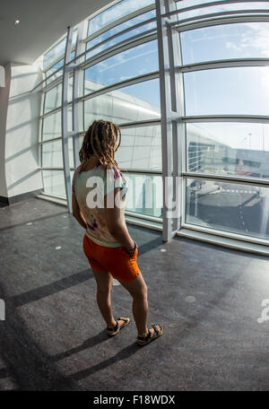 Junge Frau am internationalen Flughafen Stockfoto