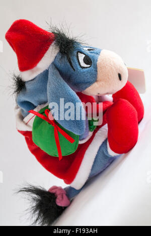 Xmas Santa Eeyore tragen Plünderung stellt weichen Kuscheltier von Winnie The Pooh isoliert auf weißem Hintergrund Stockfoto