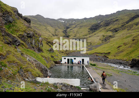 Wandern, Freibad in Island. Seljavallalaug ist ein Spaziergang durch den Hang vom Parkplatz entfernt. Stockfoto