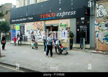 Notting Hill, London, UK. 30. August 2015. Käufer außerhalb einer bestiegen, Tesco Supermarkt als dem Notting Hill Carnival, Europas größte Straßenfest startet anlässlich der offizielle Startschuss für die zweitägige Karneval in Notting Hill mit großen Polizeiaufgebot Stockfoto