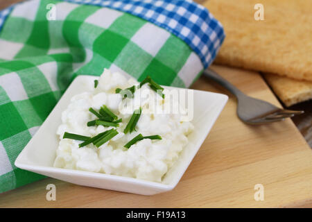 Hüttenkäse in weiße Schüssel mit Schnittlauch und Radieschen Stockfoto