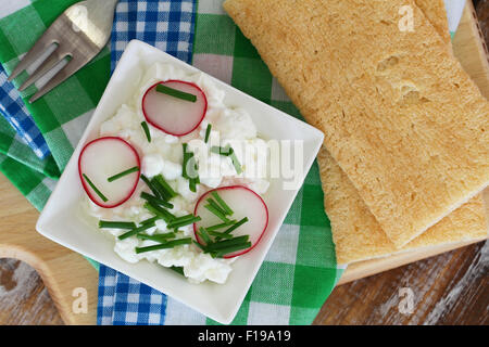 Hüttenkäse in weiße Schüssel mit Schnittlauch und Knäckebrot Stockfoto