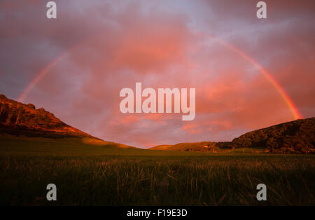 Aberystwyth, Wales, UK. 30. August 2015. Ein Regenbogen erscheint in ein feuriger Sonnenuntergang in den Hügeln in der Nähe von Aberystwyth. Bildnachweis: Jon Freeman/Alamy Live-Nachrichten Stockfoto