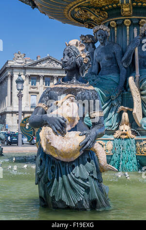 Frühling in Paris: Statue einer Frau, der einen Fisch hält. Teil einer der Brunnen der Place De La Concorde, Paris, Frankreich Stockfoto