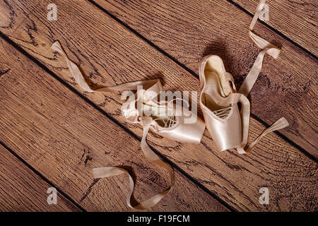 Ballett Spitzenschuhe liegen auf dem Holzboden. Retro. Das Konzept der klassisches Ballett und zeitgenössischen Tanz. Erschossen Sie Close-up. Stockfoto