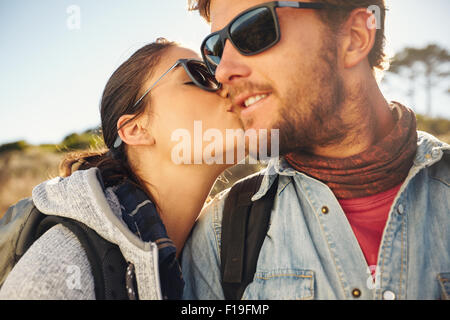 Junge Touristen Liebespaar wandern. Junge Frau küssen Wange ihres Freundes im Freien auf einer Wanderung. Stockfoto
