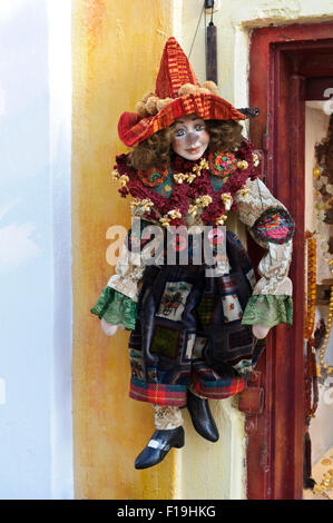 Eine bunte Clown-Marionette hängen Fäden vor einem Schaufenster in Santorini, Griechenland. Stockfoto