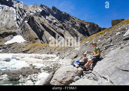 New Zealand aka Aotearoa, Südinsel, Mt Aspiring Nationalpark, Lake Tiegel, Touristen Mittagessen an einem Eisberg-See. Stockfoto