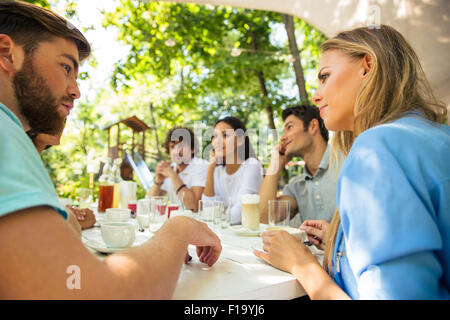 Gruppe eine glückliche Freunde am Tisch im Restaurant im Freien sitzen Stockfoto