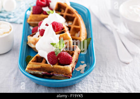 Himbeer Kokos Waffeln serviert mit frischen Beeren und Sahne Stockfoto
