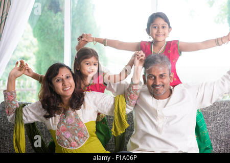 Glückliche indische Familie zu Hause. Asiatischen Eltern spielen mit ihren Kindern auf dem Sofa sitzen. Eltern und Kinder indoor Lifestyle. Stockfoto