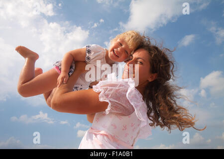 Familie, Kind und Glück Konzept - wirft Mutter ihre Tochter Stockfoto