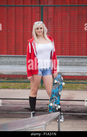 Recht jugendlich Mädchen mit Skateboard stehen. Stockfoto