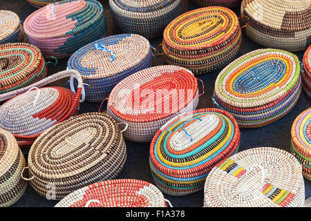 Bunte afrikanische Weidenkörbe stehen auf einer Theke im Marktplatz Stockfoto