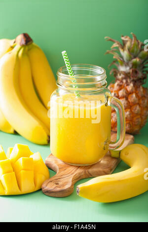 gesunde gelbe Smoothie mit Mango-Ananas-Banane in Einweckgläser Stockfoto