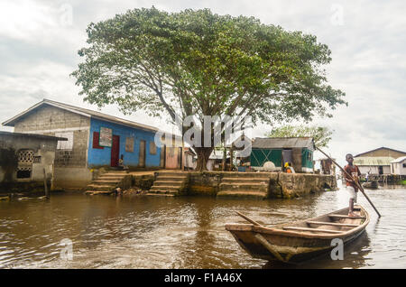 Kind auf ein Kanu und Großbaum in Ganvié, das "Venedig von Afrika", Dorf der Pfahlbauten an einem See in der Nähe von Cotonou in Benin Stockfoto