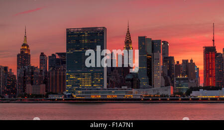 Der Hauptsitz der Vereinten Nationen und die Skyline von Midtown Manhattan von der anderen Seite des East River bei Sonnenuntergang vom Gantry State Park, Long Island City, New York Stockfoto