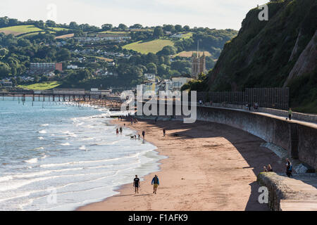 Teignmouth, Devon. 2015. die berühmten Brunel Ufermauer Küste Schiene. Stadt in den Hintergrund und die Passanten ihre Hunde am Strand Stockfoto