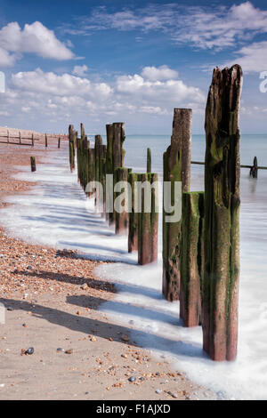 Alte hölzerne Wellenbrecher Buhnen an einem sonnigen Tag an Winchelsea Beach, East Sussex