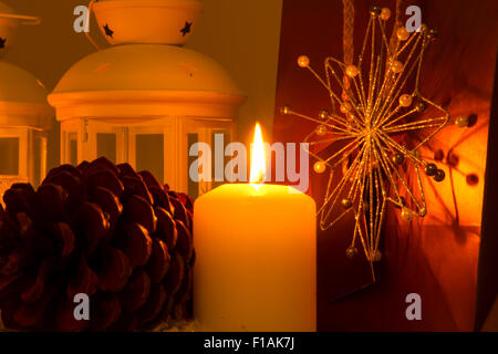 Weihnachten-Ambiente mit Kerzen, Tannenzapfen, Einkaufstaschen und Kugeln. Stockfoto