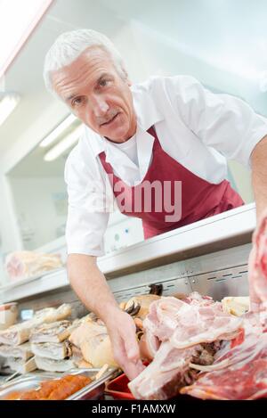 Mann arbeitet an der Käsetheke Stockfoto