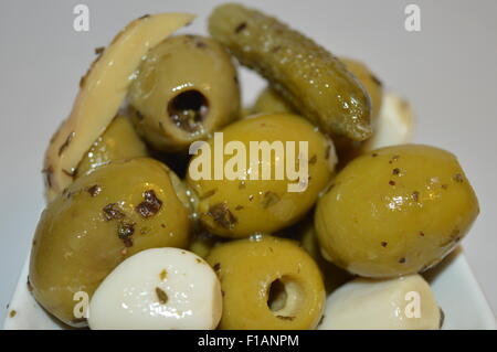 grüne Oliven mit Knoblauch, Gurke und Champignons mariniert Stockfoto