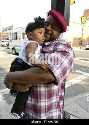 Mann und 6 Monate altes Baby Enkelin in Bedford-Stuyvesant Abschnitt von Brooklyn, New York, 2015. Stockfoto